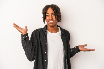 Young african american man isolated on white background confused and doubtful shrugging shoulders...