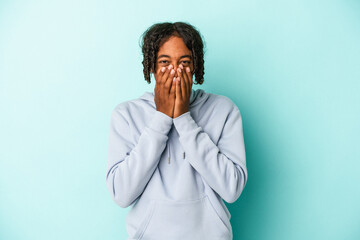 Fototapeta na wymiar Young african american man isolated on blue background laughing about something, covering mouth with hands.
