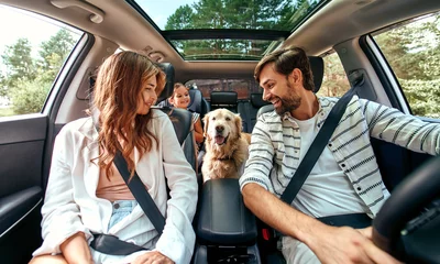 Foto op Canvas The whole family is driving for the weekend. Mom and Dad with their daughter and a Labrador dog are sitting in the car. Leisure, travel, tourism. © Valerii Apetroaiei