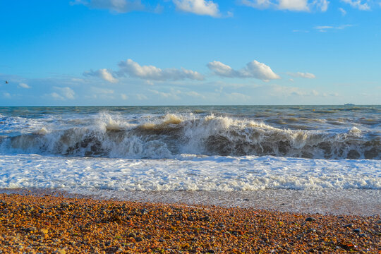 Small storm at sunset, high waves with white foam