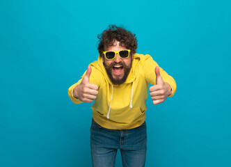 Fototapeta premium funny young man with moustache making thumbs up gesture