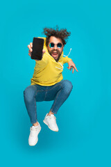 dynamic young guy showing empty screen and jumping in the air