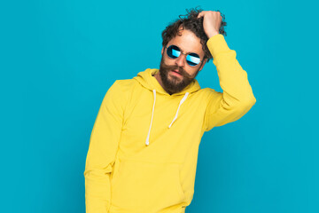 cool handsome man in yellow shirt getting fingers through hair