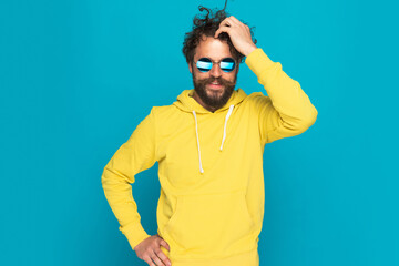 sexy retro guy with yellow hoodie scratching head and smiling