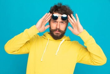 Fototapeta premium suspicious casual guy holding sunglasses above eyes and analyzing