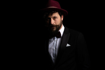 Fototapeta na wymiar businessman posing in the dark and wearing a burgundy hat