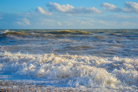 Small storm at sunset, high waves with white foam