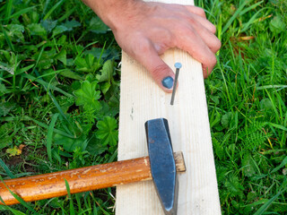 The man was hammering a nail into the board but hit on the finger of his hand. Hematoma, injury,...
