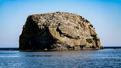 The island is noticeable in the Quiet Bay. Sakhalin, Russia. Sea of Okhotsk, Pacific Ocean