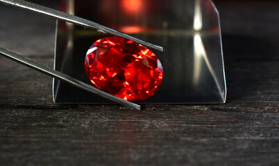 A red ruby gemstone is placed on the ground. for making jewelry