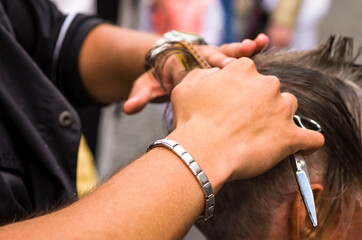 The hairdresser cuts and combs the man. Barber's hands with scissors and a hairbrush