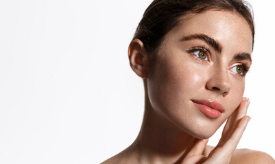 Beauty woman with freckles, thick eyebrows, touching face, using skin care lotion, anti-aging mask...