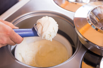 ice cream razor with ice cream ball in background of refrigerated display case