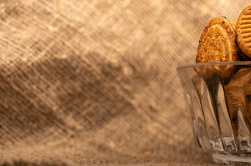 Curly cookies covered with chocolate icing in a glass vase, close-up, selective focus.