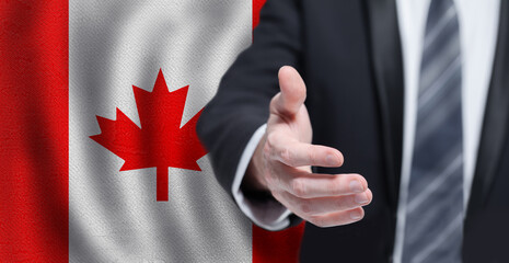 Canadian business, politics, cooperation and travel concept. Hand on flag of Canada background.