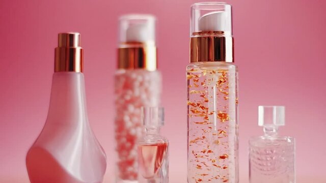 Beauty, make-up and cosmetics product promotion on pink background, perfume, fragrance and skincare bottles. High quality FullHD footage