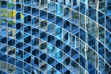 Curved glass facade of a modern office building with geometric pattern