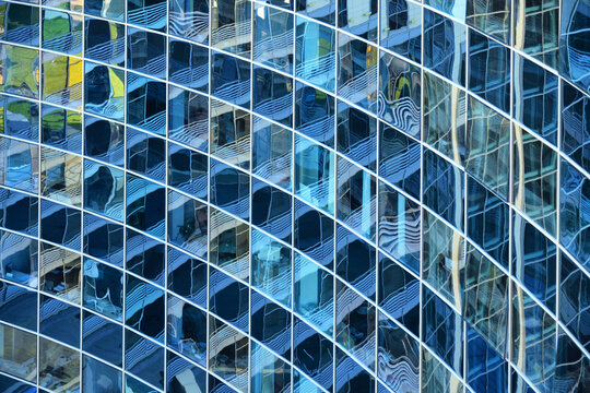 Curved glass facade of a modern office building with geometric pattern