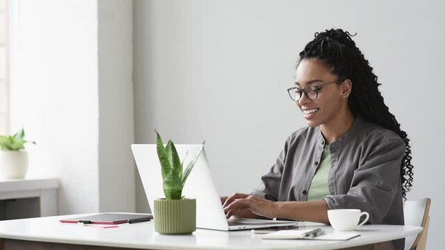 Young woman using laptop computer at office. Student girl working at home. Work or study from home, freelance, business, lifestyle concept