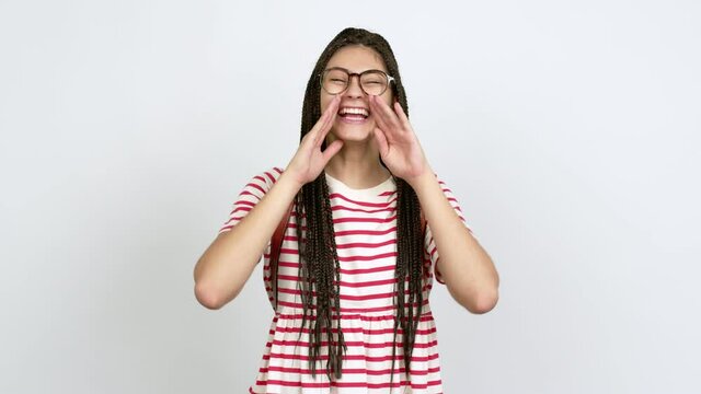 Teenager girl with braids with glasses shouting and announcing something over isolated background