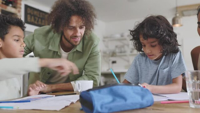 Slow motion of boys doing homework with parents