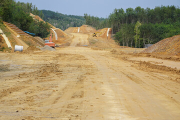 Rural road under construction across palm oil plantation . The road is under upgrading to dual...