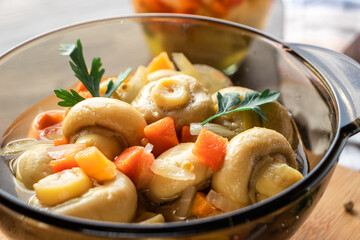 Pickled mushrooms with vegetables in a close-up in a dark mask