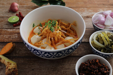 Local northern Thai food Egg noodle curry with meatballs on wood background