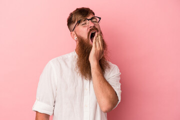 Young caucasian ginger man with long beard isolated on pink background yawning showing a tired...