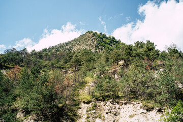 Fototapeta premium Mountain peaks against cloudy sky. Peaks of magnificent rocks located against bright cloudy sky on sunny day in nature