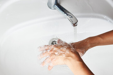 Woman washing hands with the water tap