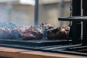 Tri-Tip Beef Roasts Being Cooked at an Outdoor Festival Charred with Smoke Wafting from the Grill
