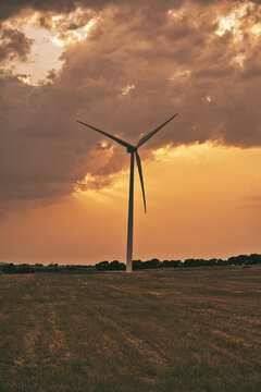 Vertical shot of sunset in the feald area wind turbine zone