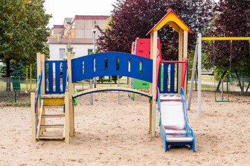 Colorful equipment with stairs and slides on a sandy playground in Poznan, Poland