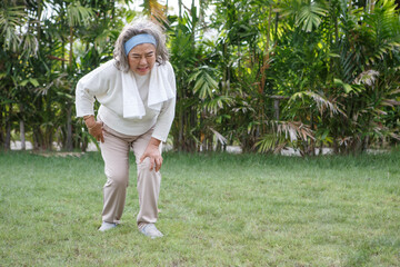 asian Senior woman sitting or flop falling in garden park and having knee pain. kneel Arthritis...