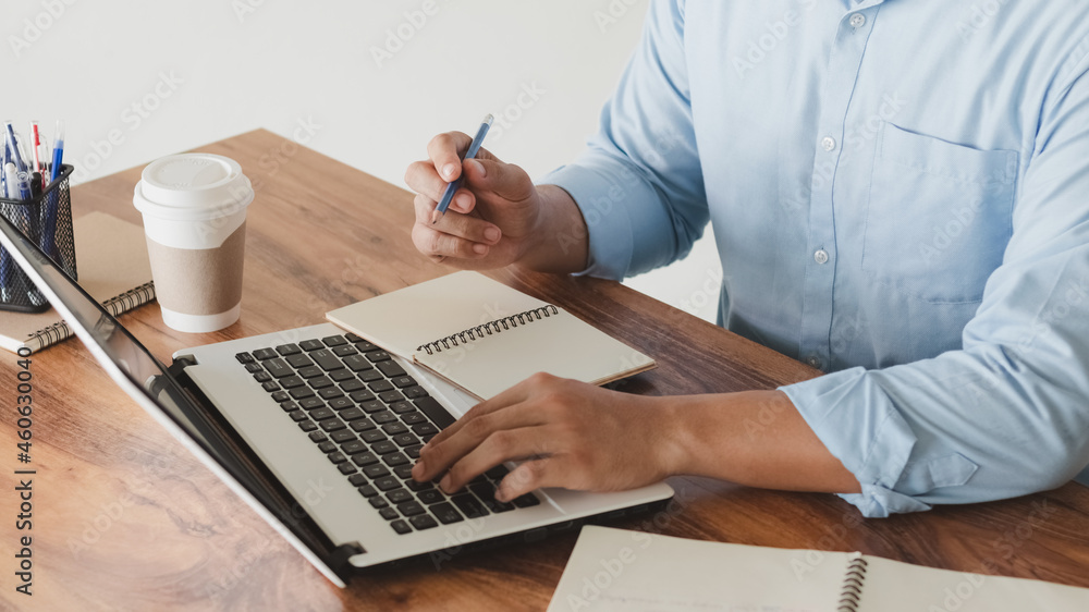 Poster young man using laptop computer and mobile phone when looking for financial information in business,