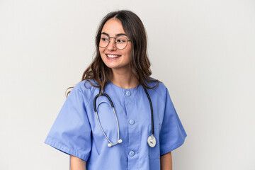 Young caucasian nurse woman isolated on white background looks aside smiling, cheerful and pleasant.