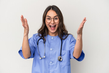 Young caucasian nurse woman isolated on white background receiving a pleasant surprise, excited and raising hands.