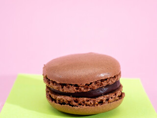 Sweet chocolate macarons, on a pink background.