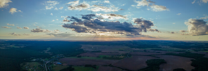 Top view of green fields, forest and cloudy blue sky in summer. Landscape with drone. Nature concept.