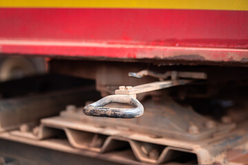 Metal handle device under the truck chassis, using as locking or release device for latching pin between truck cabin and trailer (Kingpin). Transportation safety object photo, selective focus.
