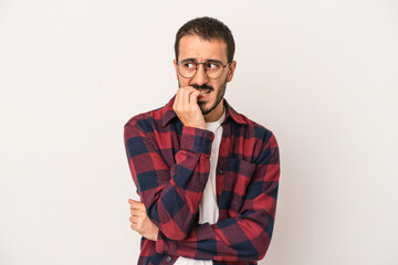 Young caucasian man isolated on white background biting fingernails, nervous and very anxious.