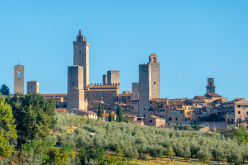 Colorful skyline of little ancient town of San Gimignano, Tuscany, along via Francigena - obrazy, fototapety, plakaty