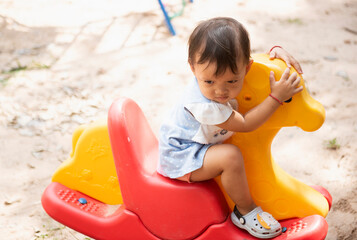 Picture of an Asian girl on an outdoor carousel.