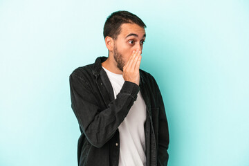 Young caucasian man isolated on blue background being shocked because of something she has seen.