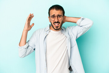Young caucasian man isolated on blue background screaming with rage.