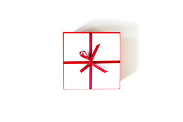 Gift white box with red ribbon and bow isolated on white. View from above.