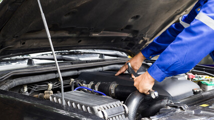 Car mechanic working on car engine, car maintenance concept.