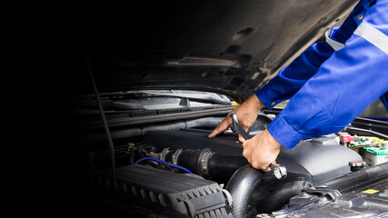 Car mechanic working on car engine, car maintenance concept.