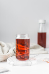 Cold brew black tea in glass cup, clear cold brew beverage in a can shaped glass